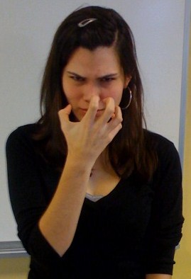 ASL sign for angry: tense claw hand near the nose, expressing strong feeling